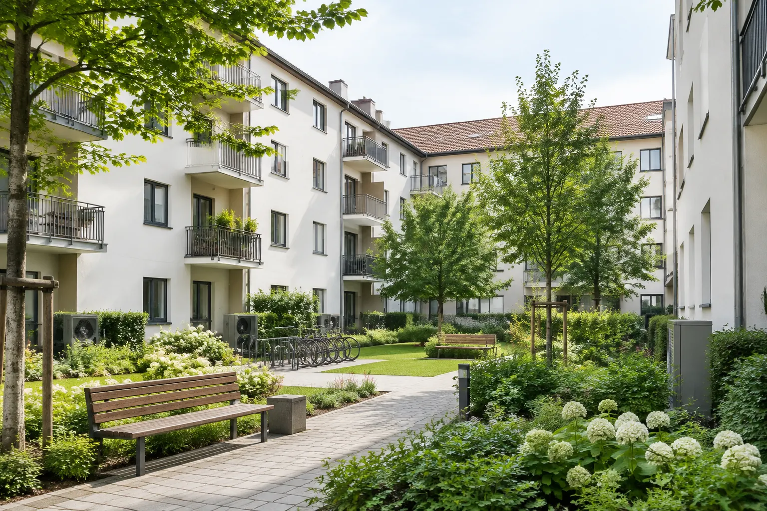 Symbolbild: sanierte Wohnanlage mit begrüntem Innenhof und Sitzbank
