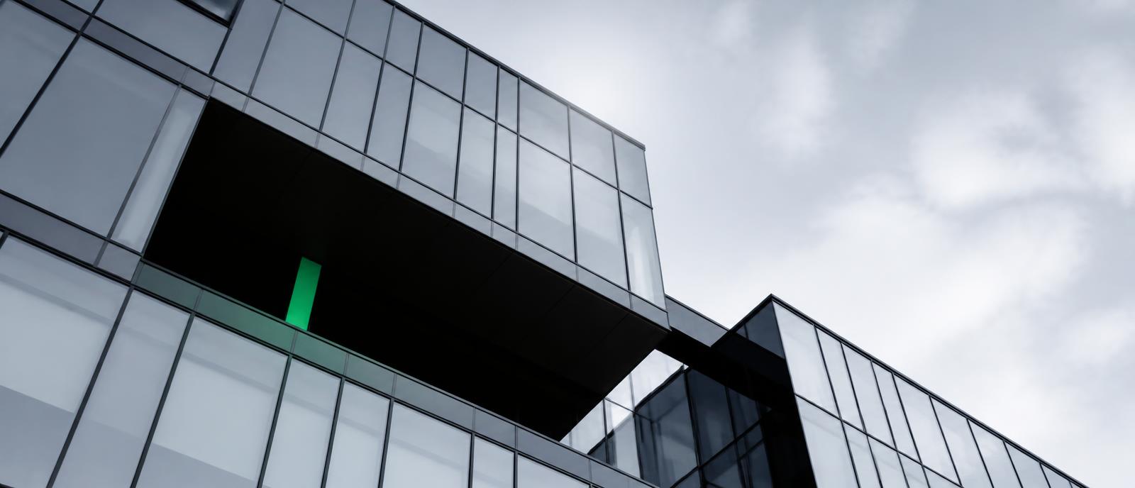 Glasfassade eines modernen Bürogebäudes von unten
